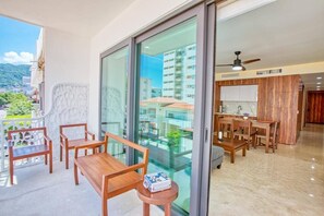 Een balkon met houten meubels en uitzicht op een stadsgezicht.