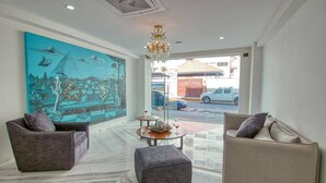 A modern living room with two sofas, a coffee table, and a large mural on the wall.