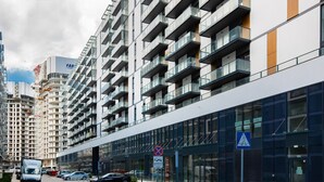 Un edificio moderno con varios pisos, ventanas amplias y una señal de paso para peatones.