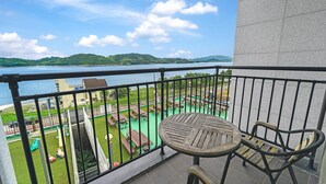 A balcony with a view of a park and a body of water. - Namhae Spring, Summer, Fall, Winter Pet- (Namhae)