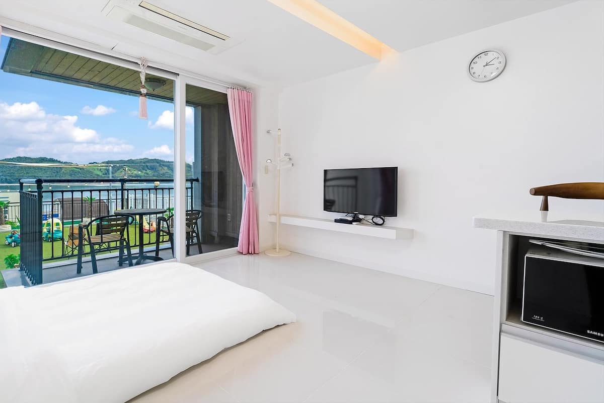 Une chambre d’hôtel moderne dotée d’un balcon, d’une télévision et d’un meuble pour télévision Samsung.