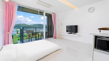 Ein modernes Hotelzimmer mit Balkon, Fernseher und Samsung TV-Stand.