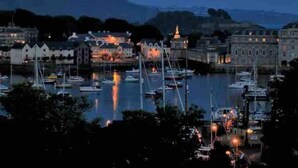 A marina with boats docked and buildings in the background. - Cozy Coastal Apartment (Plymouth)