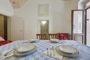 A dining table set with plates, cutlery, and a checkered tablecloth.