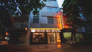 Fasaden på Ngoc Ha-hotellet med en tydligt markerad entré och skyltar.