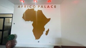 Una pared con un mapa de África y el texto "AFRICO PALACE" en la parte superior.