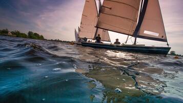 Ein Segelboot mit mehreren Segeln auf ruhigem Wasser.