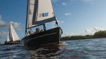 A sailboat with a name on the side, sailing on water.