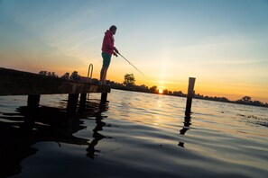 A person fishing at a pier during sunset. - Waterlodge Goudule in Nes (Nes)