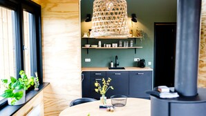 Une cuisine chaleureuse avec une table ronde, un luminaire suspendu et une cuisinière intégrée.