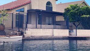A house with a pool, a boat, and a tree. - Lakefront Home | Community Pool & Hot Tub (Chandler)