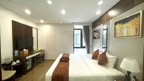 A modern hotel room with a large bed, a desk, a television, and a painting on the wall. - Catba View Hotel (Hai Phong)