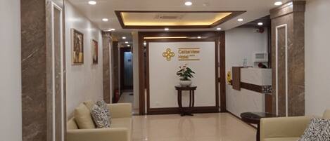 A hotel lobby with a reception desk, seating area, and a sign for Caliba View Hotel.