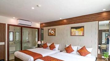 Une chambre d’hôtel avec deux lits, un grand miroir et une armoire.