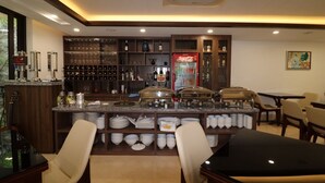 A bar area with a Coca-Cola refrigerator, wine glasses, and bottles. There are dining tables and chairs. - Catba View Hotel (Hai Phong)