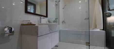 A modern bathroom with a glass-enclosed shower, a large mirror, and a white vanity.