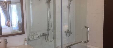 Un baño moderno con ducha envuelta en vidrio, una bañera y un lavamanos.