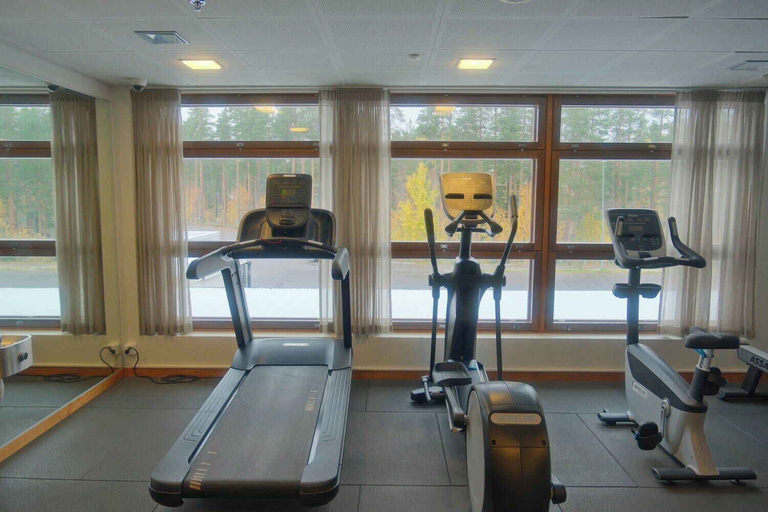 A gym with treadmills, elliptical machines, and stationary bikes.