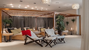 Un espace de détente moderne, avec des meubles en osier, un éclairage d’ambiance et des plantes en pot.