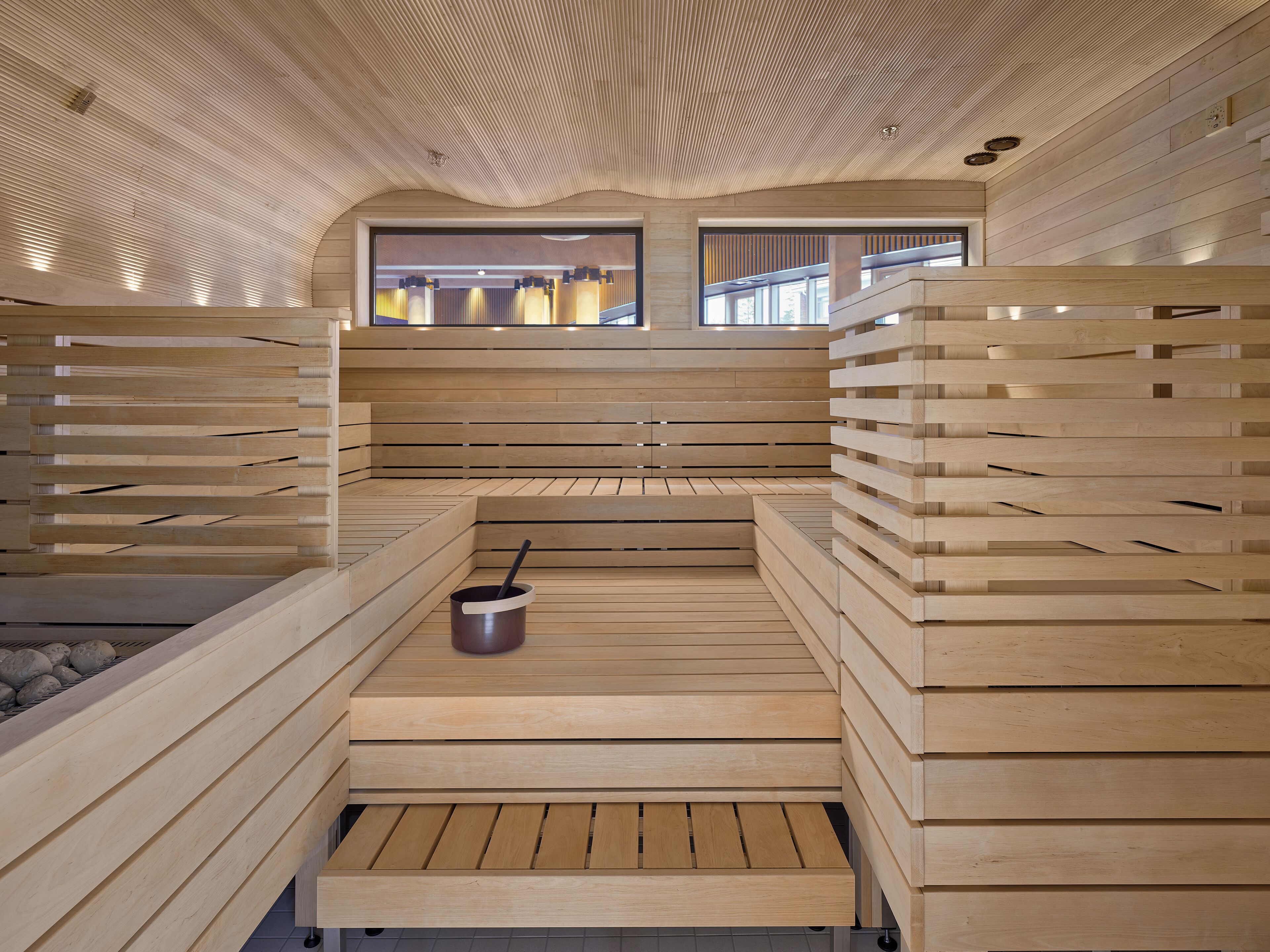 Una sauna con bancos de madera e hidromasaje central.