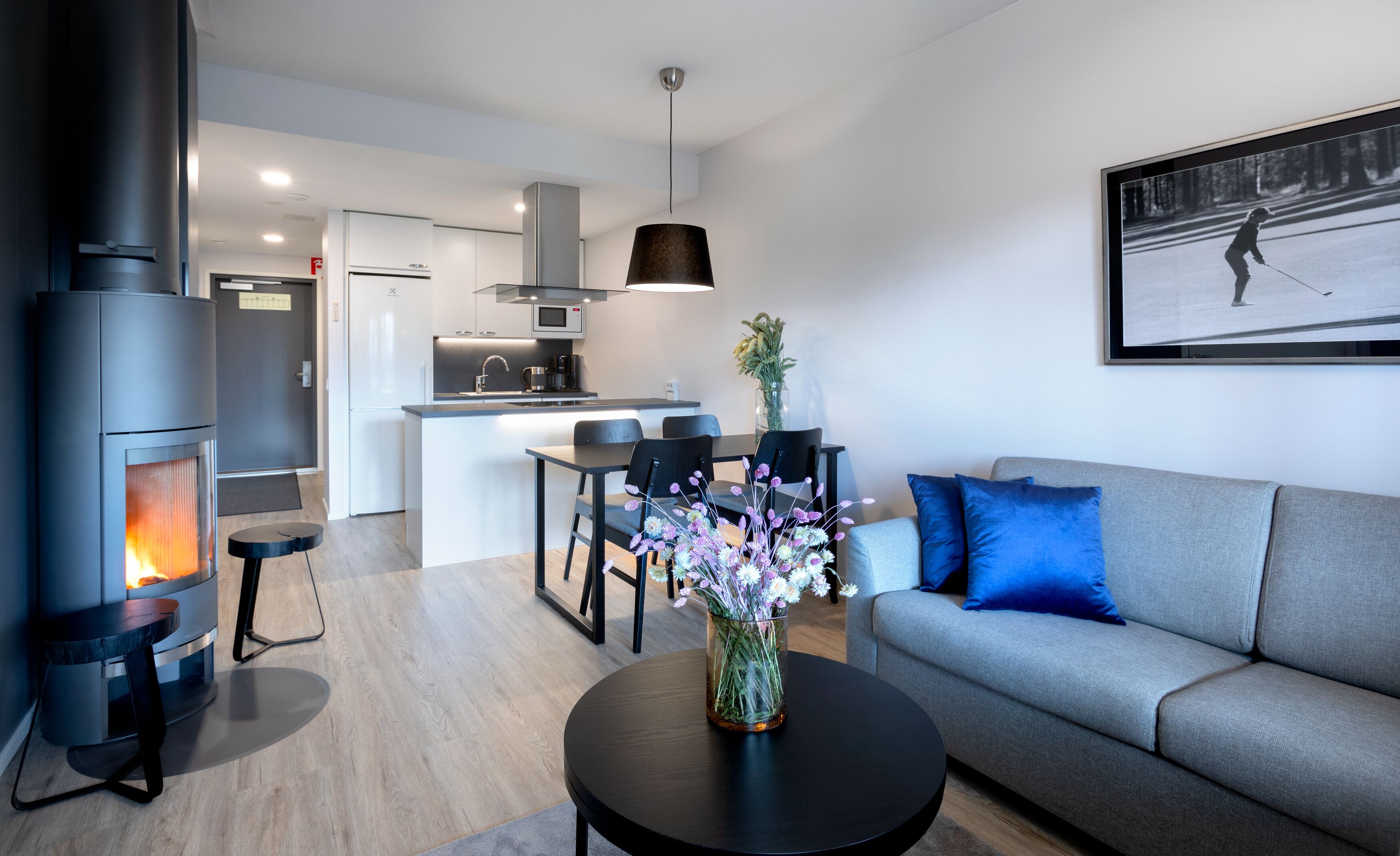 Una sala moderna con chimenea, un comedor y una cocina.
