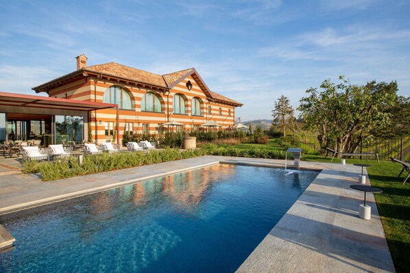A large building with a pool, outdoor seating, and a well-maintained lawn. - Villaggio Narrante - Cascina Galarej (Serralunga d'Alba)