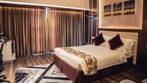 A modern hotel room with a large bed, a desk, and a chair. - Grand River View Hotel (Rajshahi)