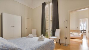 Una camera da letto con un letto, un armadio, una sedia e un divano.
