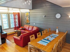 A cozy living area with a red sofa, wooden dining table, and a painting on the wall. - Kelkka 2 by Interhome (Salla)
