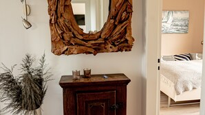 A room with a wooden cabinet, a large mirror, and a potted plant. - Vacation home with 80 sqm - on Ballumweg on Sylt (Sylt)