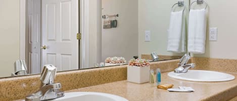 A bathroom with two sinks, a mirror, and a door.