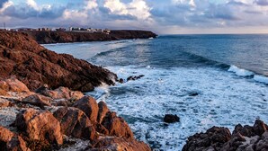 Un paysage côtier caractérisé par un terrain rocheux et une vue sur la mer.