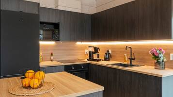 Een koelkast, een magnetron, een vaatwasser, kookgerei, borden en bestek