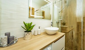Deluxe appartement | Badkamer | Een douche, een regendouche, een haardroger, handdoeken