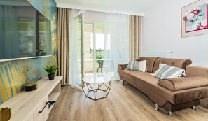 Deluxe suite (Wyspiańskiego 39) | Woonkamer | Een 48-inch smart-tv met digitale zenders en een televisie