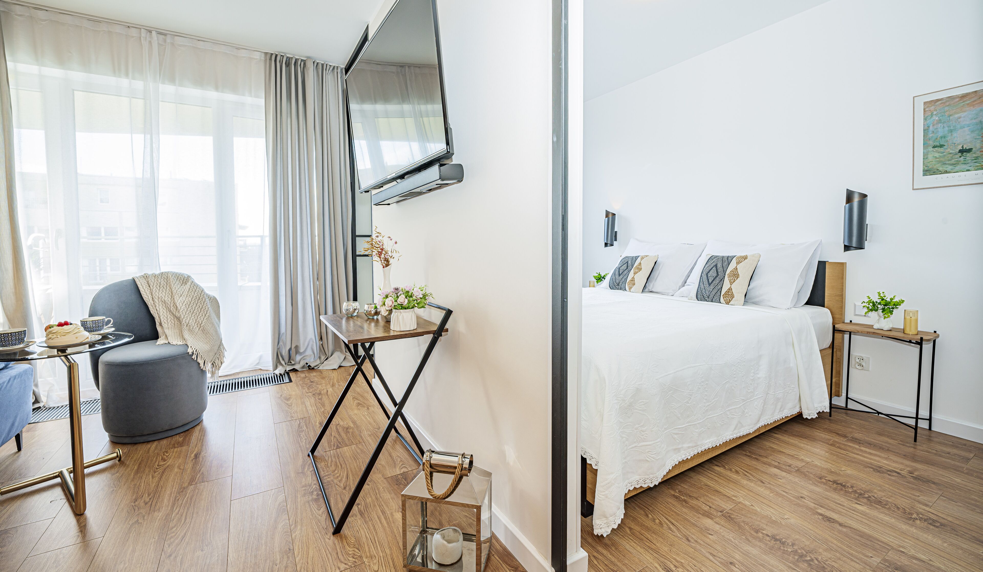 Et moderne hotelværelse med seng, skrivebord, stol og et vindue med gardiner.