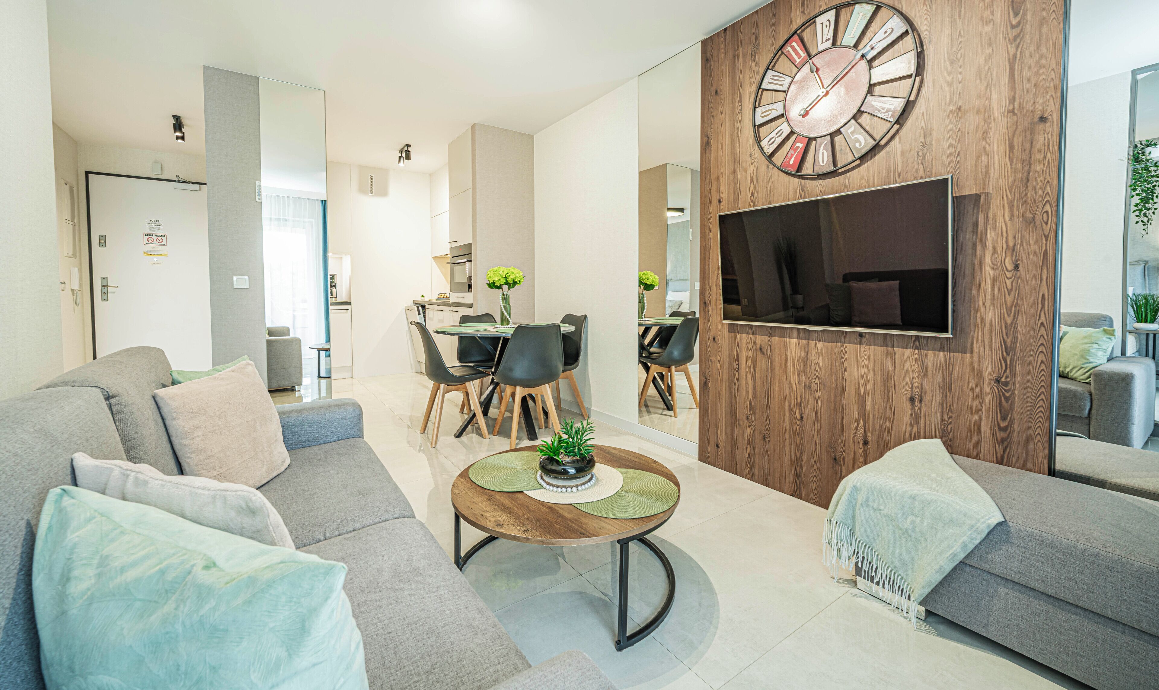Un salon moderne comprenant un canapé, une table basse et un coin repas avec des chaises et une table.