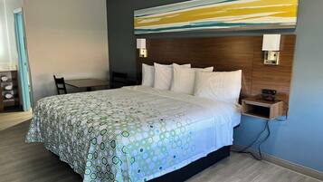 Una habitación de hotel con una cama grande, un cabecero de madera, un escritorio y una silla.