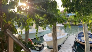 A dock with boats, a wooden walkway, and a view of the water. - Beautiful condo with sea view (Kralendijk)