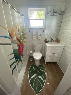 Een badkamer met toilet, wastafel en douche.