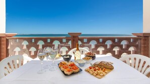 A table set with food and drinks, overlooking a clear blue sky and sea. - 2856 Residence Bellavista- APP 8 II P Fronte Mare by Barbarhouse (Porto Cesareo)
