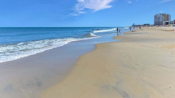 A beach with a clear sky, calm sea, and buildings in the background. - 2 bedroom 2 bath with outdoor pool, oceanblock - great prices! (Ocean City)