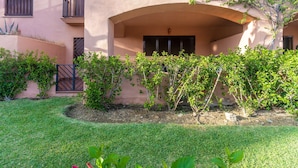 Ein Gebäude mit Flachdach, Balkon und kleinem Garten.
