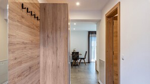 A modern interior with a wooden wall, a dining area, and a wooden door.