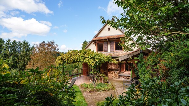 Una casa con giardino, un pontile in legno e un vialetto in pietra.