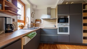 Una cucina moderna dotata di forno a microonde, forno e macchina del caffè.