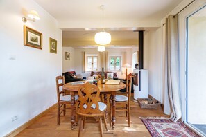 Un coin repas avec une table et des chaises en bois, un lustre et des tableaux encadrés au mur.