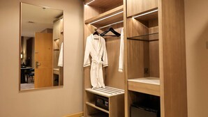 Un baño moderno con un espejo grande, armarios de madera y un lavabo empotrado.