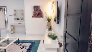 A modern interior with a white console table, a large mirror, a painting, and a black door. - 3-room apartment near the center. Air-conditioned and free WLan (Lomé)