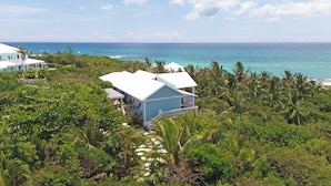 A coastal property with a large house, lush greenery, and a view of the ocean. - Kokomo Cay - Luxurious Home Near the Beach, with Spectacular Ocean Views (Hope Town)